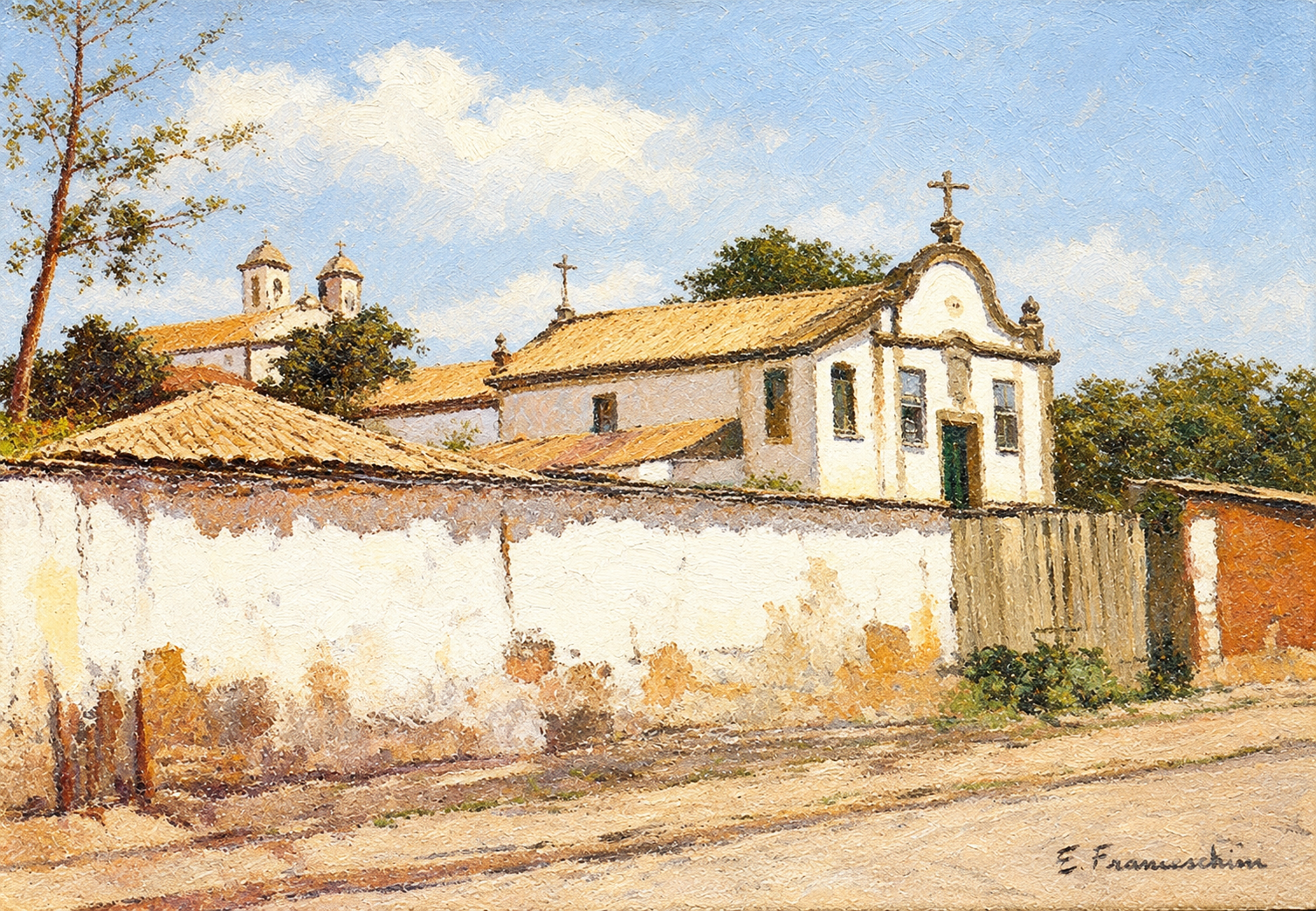 Tiradentes — Igreja e telhados aparecem por trás de um longo muro claro.
